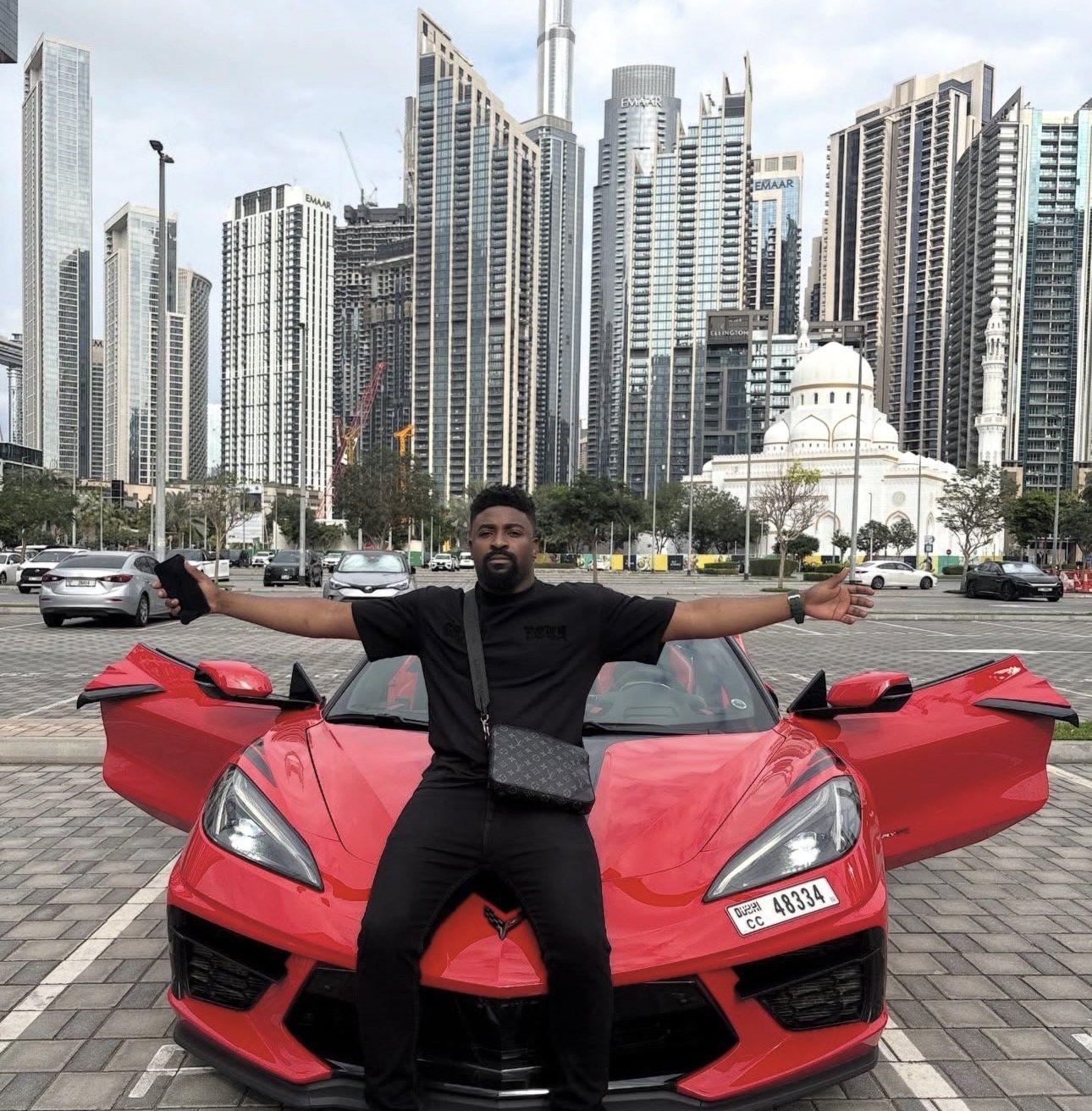 Portrait seated on a red sports car